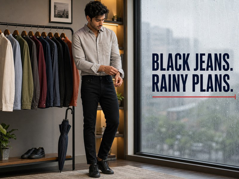 Man styling black jeans with a shirt beside a rain-streaked window | 