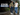 Two men wearing dark and light blue cotton jeans on a rain-wet city walkway |