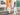 Man and woman in Spykar white jeans with orange and green shirts on rain-washed urban steps | 